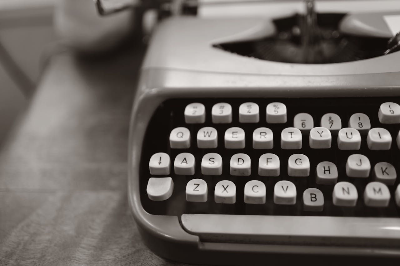our-story Detailed close-up of a vintage typewriter keyboard in black and white.